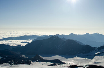 dawn in the mountains.mountain peaks, glaciers and clouds are illuminated by the morning sun.