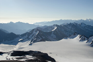 dawn in the mountains.mountain peaks, glaciers and clouds are illuminated by the morning sun.