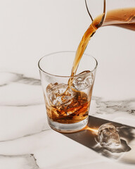 Cold Brew Coffee Poured Over a Beautiful Clear Glass Filled with Ice - Refreshing and Chilled Coffee on Minimalist Background 