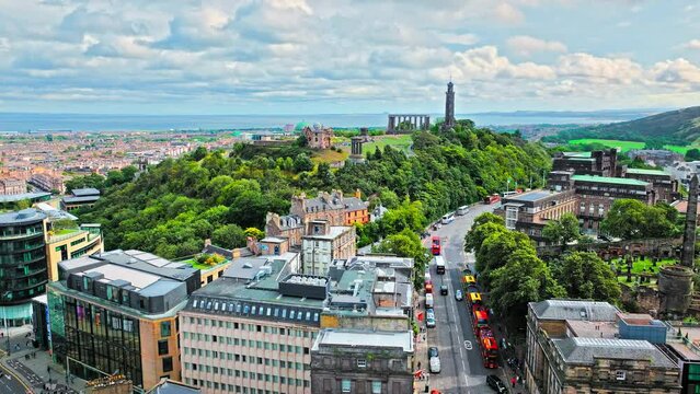 Aerial view of Edinburgh Castle with green gardens in Scotland. Historic castle and barracks housing the Crown Jewels and National War Museum of Scotland stands on Castle Rock.
