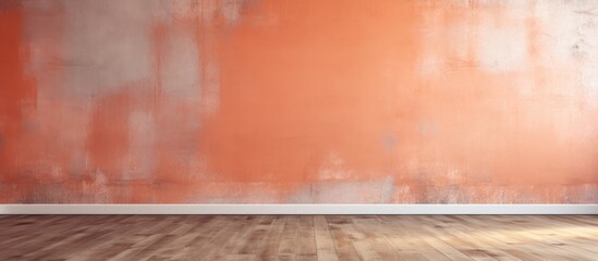 An empty room with a vibrant orange wall and a wooden floor. The room appears spacious and clean, with natural light streaming in from a window.
