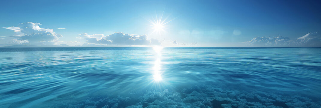 A serene blue ocean scene with  blue waters, blue sky  and sunlight reflecting on water, blue sea and sky background,banner panorama tranparent water sea
