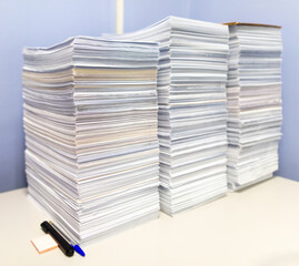 Stacks of papers on a table in the office