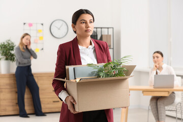 Unemployment problem. Woman with box of personal belongings in office