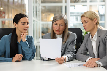 Lawyers working together with documents at table in office