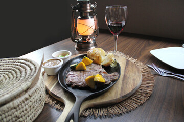 Roasted beef accompanied by peppers and baked potatoes with tortillas, beans and lemons Mexican style
