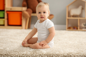 Cute little boy on rug in children's room