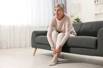 Arthritis symptoms. Woman suffering from pain in leg at home