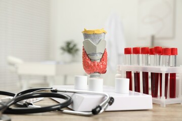 Endocrinology. Stethoscope, model of thyroid gland and blood samples in test tubes on table indoors
