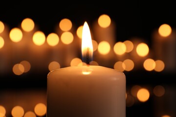 Burning candle in darkness, closeup. Memory day