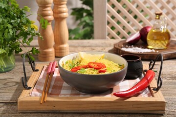 Stir-fry. Tasty noodles with vegetables and meat in bowl served on wooden table
