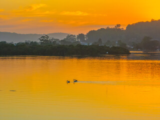Fototapeta premium Sunrise along the waterfront with reflections on the bay water