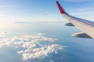 View from the airplane window at a beautiful cloudy sky and the airplane wing