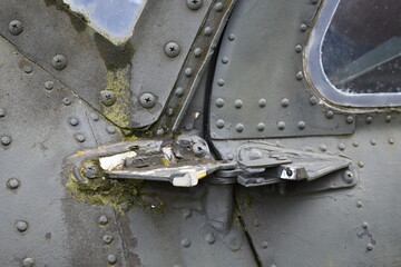 Helicopter door hinge, old and covered in algae.