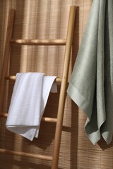 Soft terry towels and wooden ladder indoors