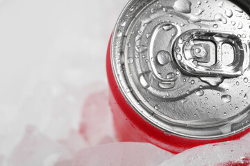 Energy drink in wet can and ice cubes on light background, closeup. Space for text