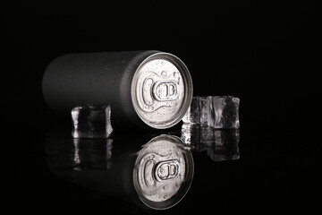 Energy drink in wet can and ice cubes on black background
