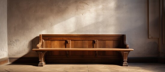 A wooden bench is positioned next to a wall in a spacious room, creating a simple and functional seating area within the enclosed space.