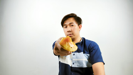 Asian man is eating mango pieces using a fork and really enjoying it. food advertising concept isolated on white background