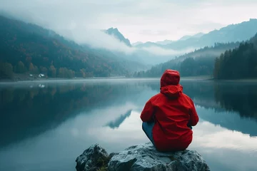 Foto op Plexiglas Wanderer in roter Jacke an einem See in den Bergen  © Herzog