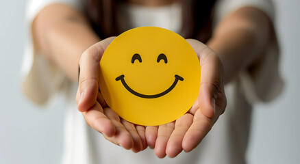 Hands holding yellow happy smile face paper cut, good feedback rating,positive customer review, experience, satisfaction survey ,mental health assessment, child wellness,