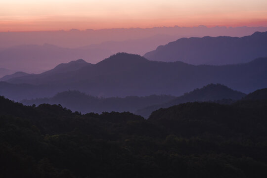 nature traveling with orange sky and layer of mountain with sunrise background