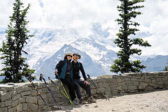 Couple posing for photos at Glacier Overlook. Sunrise Trail. Mount Rainier National Park. Washington State.