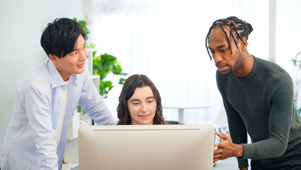 Multinational people talking while looking at desktop PC in the lobby. International business.