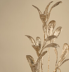 a branch with artificial leaves covered with gold sequins, a festive decoration, isolated © Елена Челышева