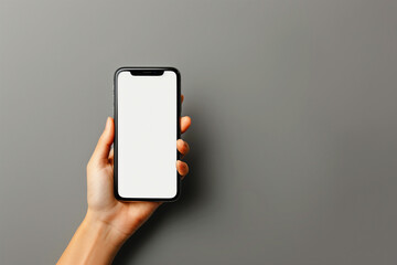 Concept of use of the smartphone. A smartphone with a white blank screen in the hand of a woman. On a gray background.