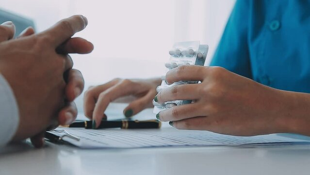Female pharmacist holding medicine bottle giving advice to customer in chemist shop or pharmacy