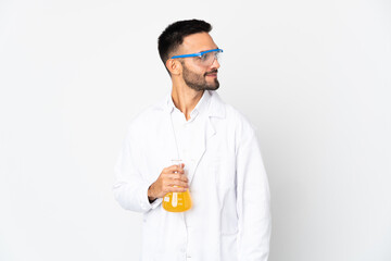 Young scientific man isolated on white background looking to the side and smiling