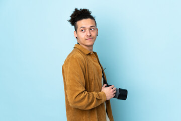 Photographer man over isolated blue background laughing