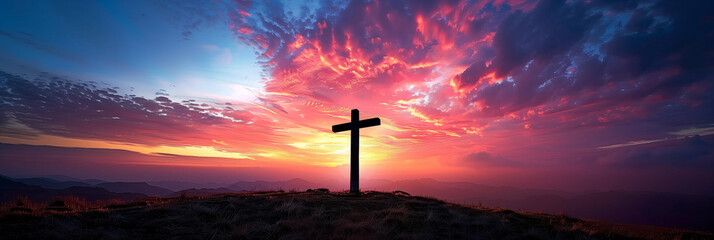 Dramatic sunset sky with vibrant pink and purple clouds behind a solitary cross on a mountain, symbolizing Easter or Christian faith, with space for text