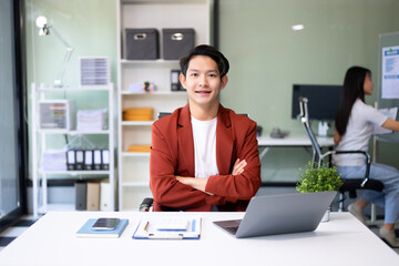 Young attractive Asian male office worker business suits smiling at camera