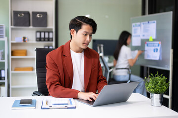 Young attractive Asian male office worker business suits smiling at camera