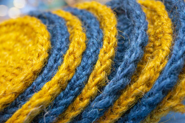 Products knitted from yellow and green jute lie alternately close to the texture of jute.