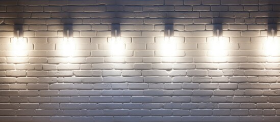 A white brick wall is featured with three sleek, modern lights attached to it. The lights illuminate the wall, casting a soft glow around them.