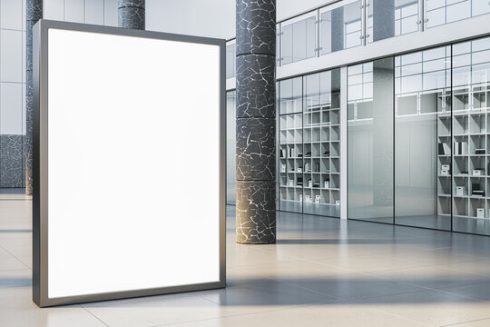 Contemporary empty white billboard in interior with glass partitions, columns and concrete flooring. Mock up, 3D Rendering.