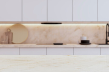 An empty, modern kitchen interior with a marble tabletop in the foreground and a blurred counter in...