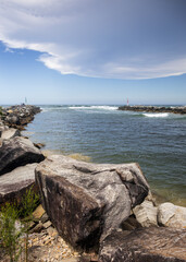 Big rocks and ominous storm clouds in sky over water at breakwall on Wooli Wooli River