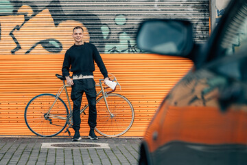 fashionable young man with bicycle in urban background