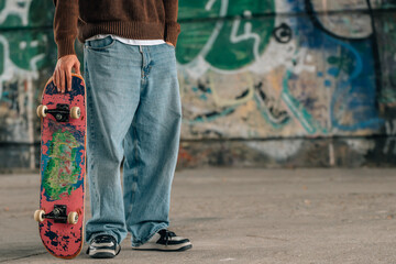 close-up of hands of young man with skateboard on the street