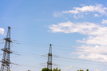 High voltage towers with sky background. Power line support with wires for electricity transmission. High voltage grid tower with wire cable at distribution station. Energy industry, energy saving
