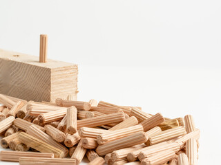 Pile of  Wooden fluted Dowel pins with wooden board isolated on a white background