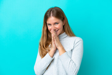 Young blonde woman isolated on blue background keeps palm together. Person asks for something