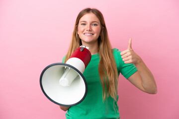 Young blonde woman isolated on pink background holding a megaphone with thumb up
