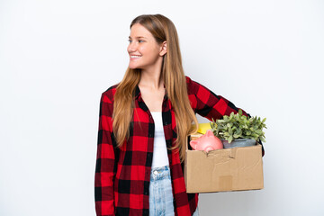 Young caucasian woman making a move while picking up a box full of things isolated on white...
