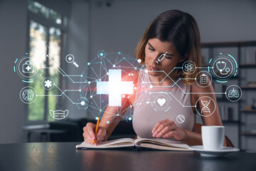 Smiling woman in casual wear taking notes in notebook at office workplace with coffee cup. Concept distant business education, information technology, dreaming, thinking. Health care medical drawings