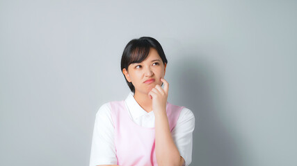 悩むエプロンをつけた女性　保育士　介護士